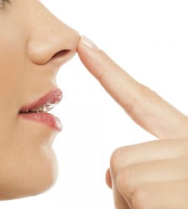 mujer tocando su nariz