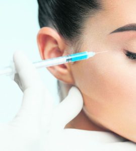 mujer poniendo inyeccion de vitaminas cara