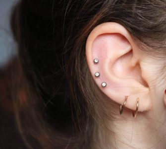 oreja de mujer con piercings